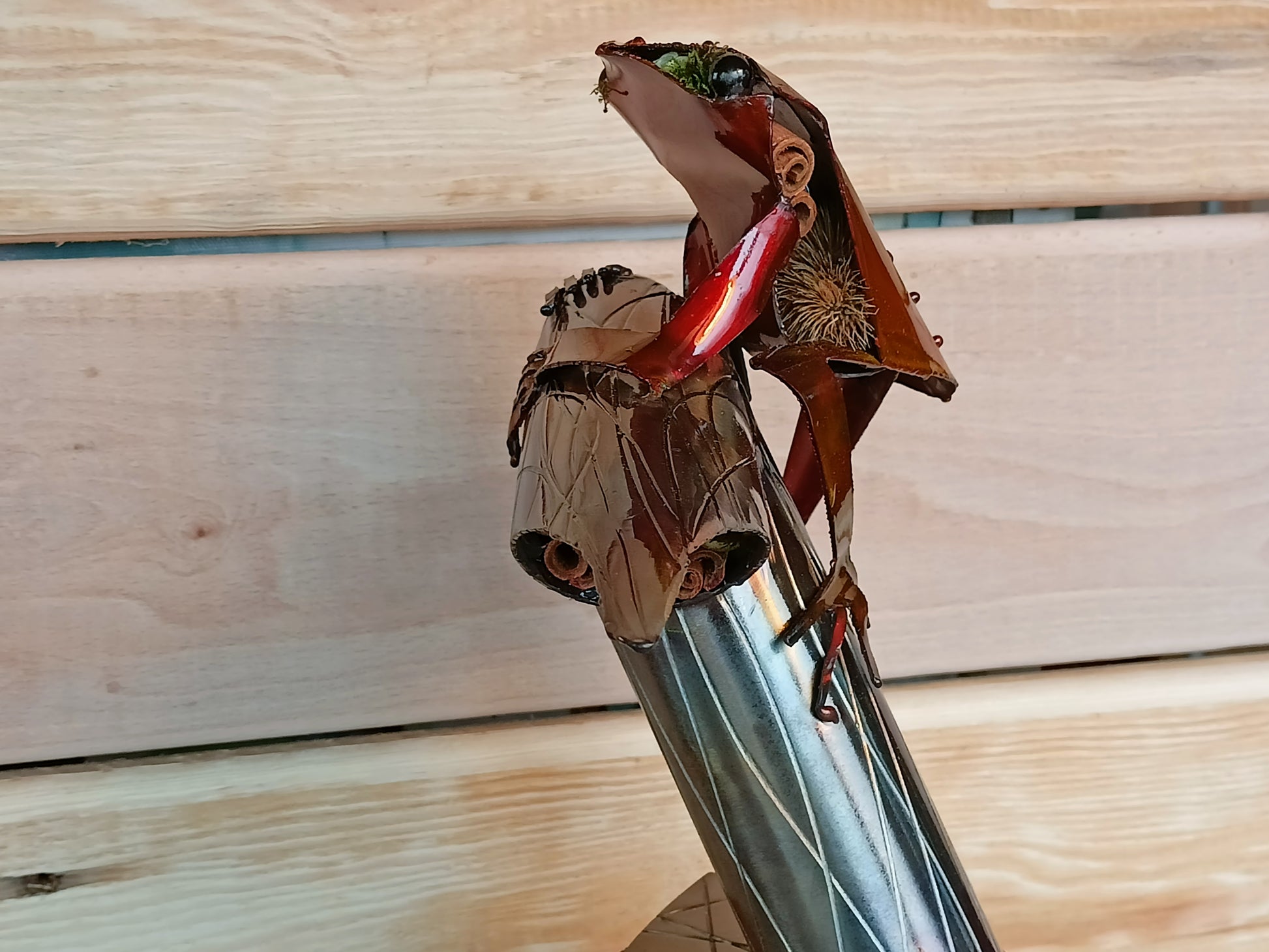 Red Tree Frog sitting on a branch inspired sculpture made from 100% upcycled metal