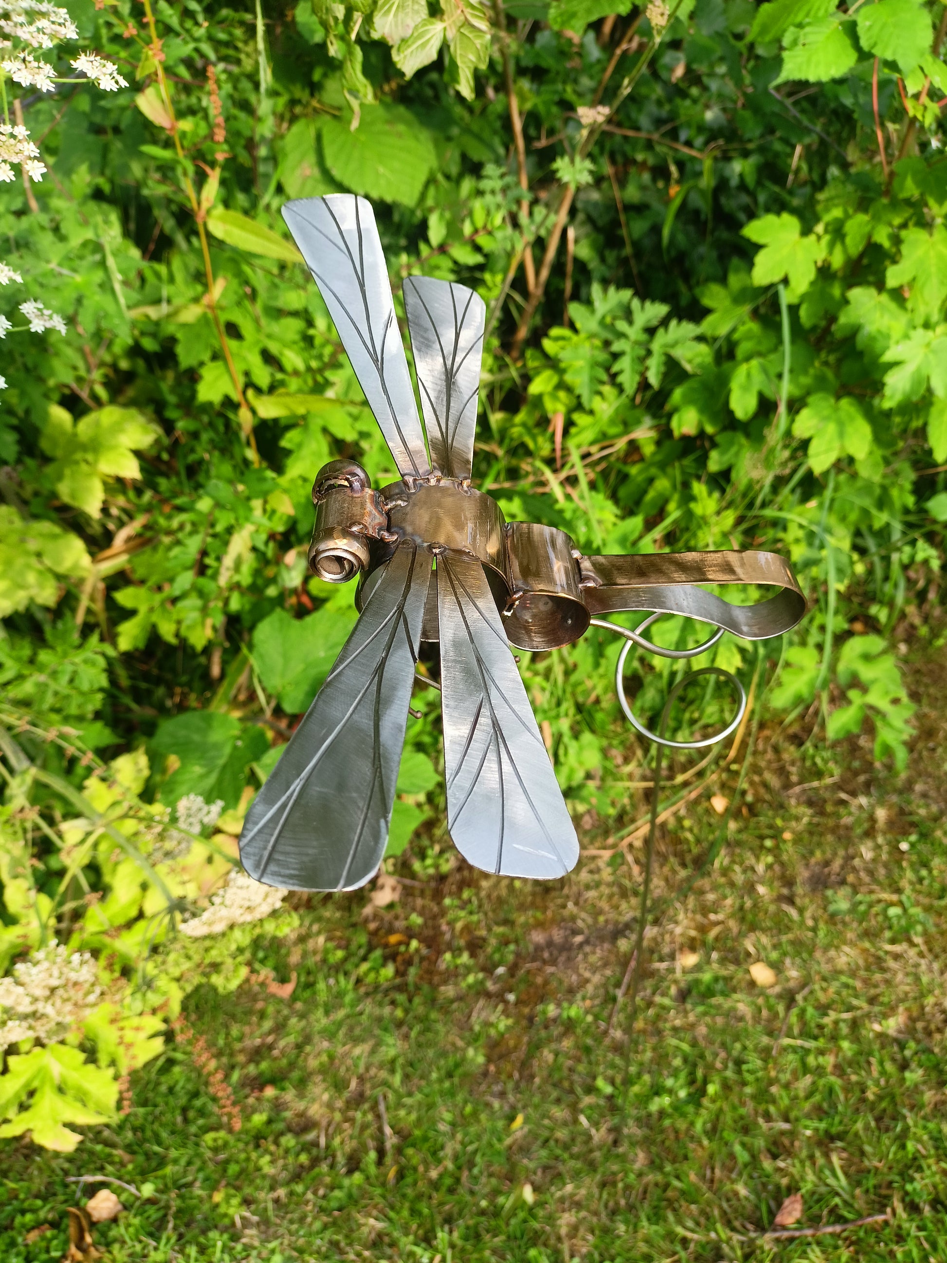 A metal dragonfly sculpture pure silver and in flight