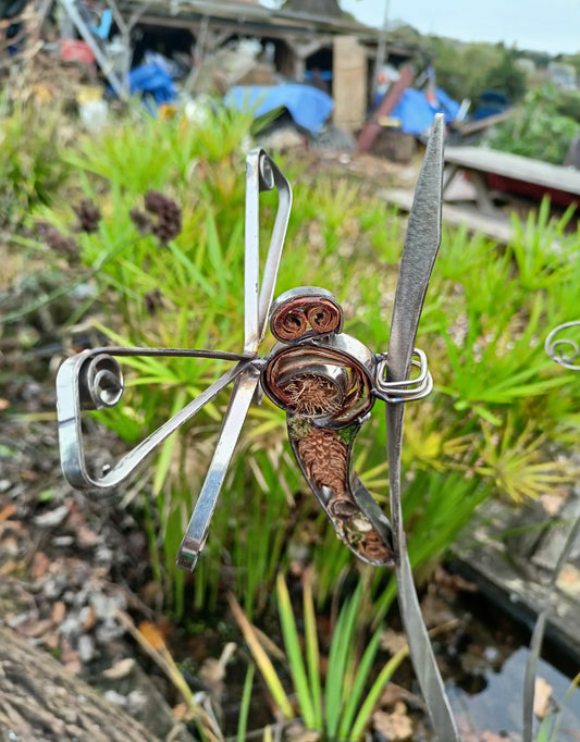 Fine dragonfly clinging to a spiral of stainless steel. With organic pattern fillings.